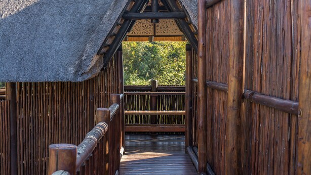 A wooden bridge with a thatched roof leading to a wooden deck. - Kruger Park Lodge Unit 608B (Mbombela)