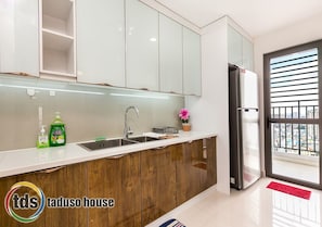Modern kitchen with white cabinetry, wooden countertop, and a stainless steel sink.