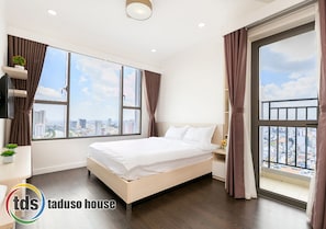 Relax in this serene bedroom with a large bed and city view.