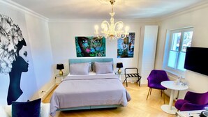 Een moderne slaapkamer met een bed, een bureau, een stoel en een televisie.