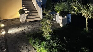 Een modern huis met een geplaveid pad dat leidt naar een trap.