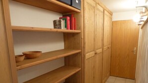 A wooden cabinet with multiple shelves and a door.