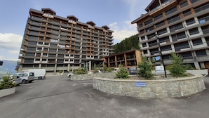 A multi-story hotel with balconies, a stone retaining wall, and a sign indicating a circulation area.