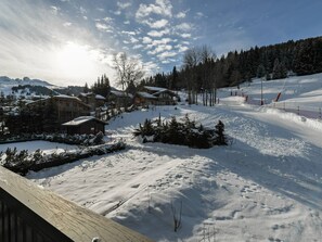 Estació d'esquí amb paisatge nevat, cabanes de fusta i una pista d'esquí.