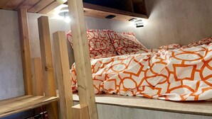 A bedroom with a wooden bunk bed, a patterned bedspread, and a ceiling light fixture. - 2* T2 in Courchevel, slope access, parking, valley view, 4 pers. (Courchevel 1850)
