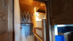 A compact kitchen with wooden cabinets, a sink, and a blue chair. - 2* T2 in Courchevel, slope access, parking, valley view, 4 pers. (Courchevel 1850)