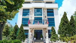 The exterior of the Golden Hotel with a modern facade, large windows, and a prominent entrance. - Golden Hotel (Pristina)