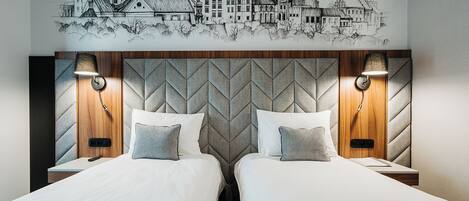 Habitación de hotel con dos camas, cabecero de madera y un mural urbano en la pared.