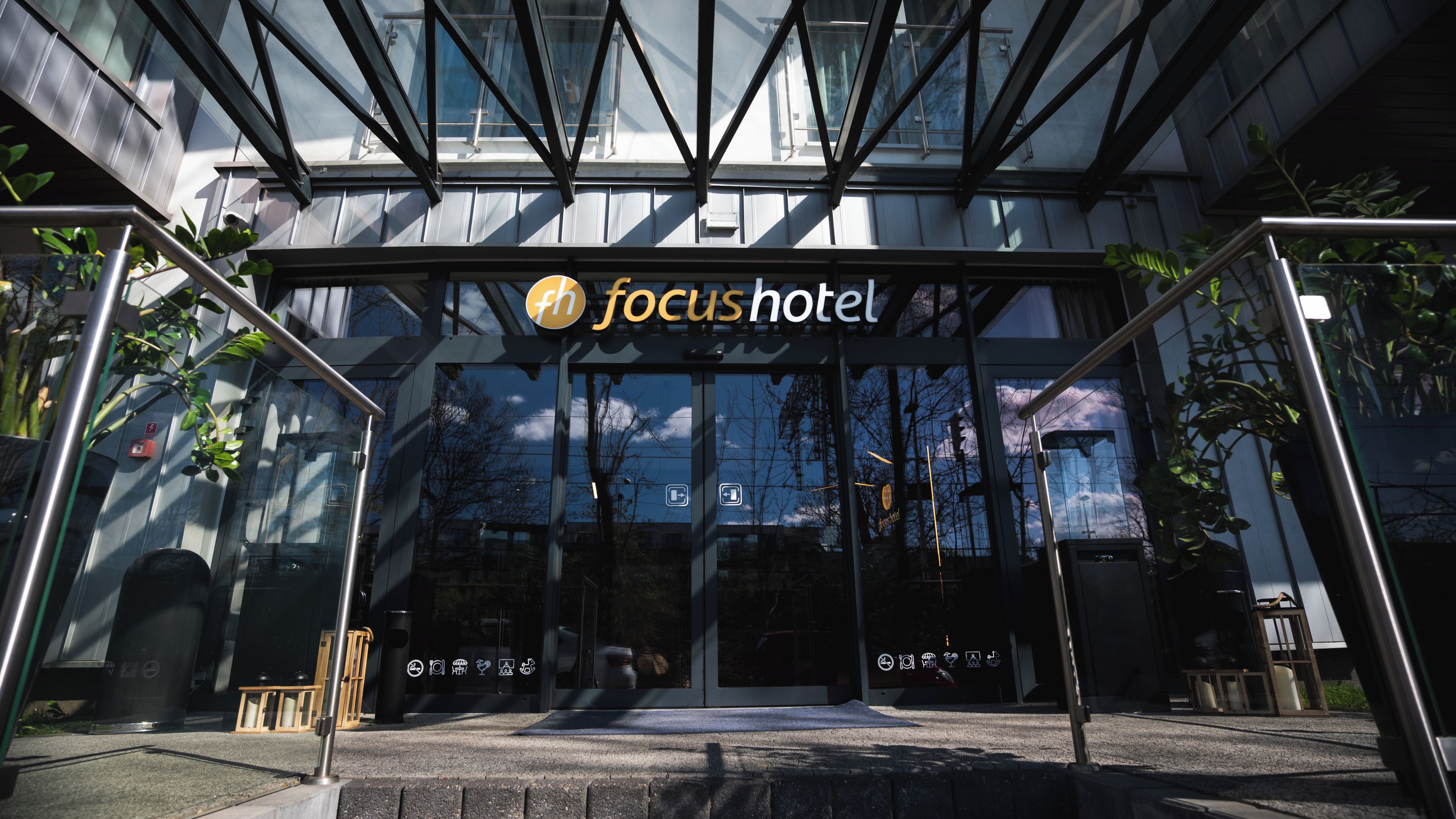 The entrance to a hotel with a modern glass facade and a sign reading 'focus hotel'.