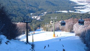 A ski lift with skiers descending a snowy slope.