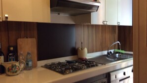 A kitchen with a gas stove, a built-in oven, a microwave, and a stainless steel range hood.
