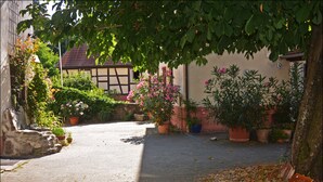 A cobblestone pathway leading to a traditional building with a sloped roof. - Hotel Herberge zur Traube (Bad Wimpfen)