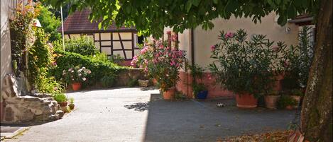 A cobblestone pathway leading to a traditional building with a sloped roof.