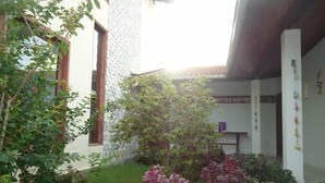 A courtyard with a small tree and various plants. - Suites Solanas de Porto - Porto de Galinhas (Ipojuca)