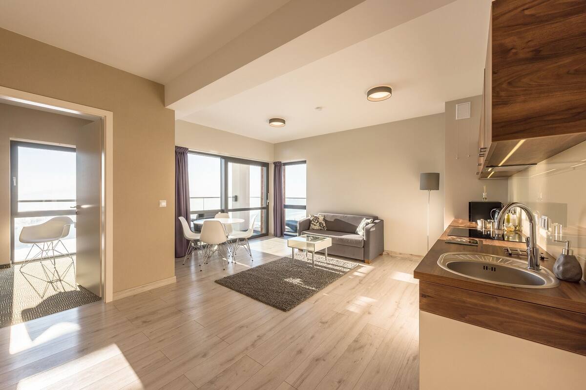 Um apartamento moderno com cozinha, sala de jantar e sala de estar.