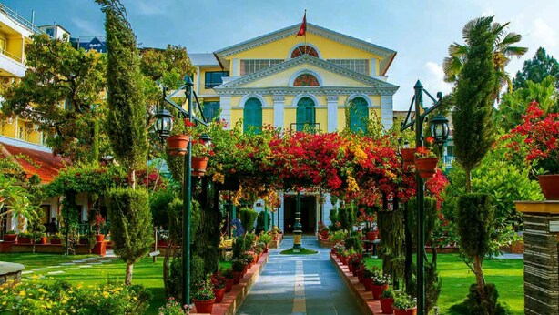 A hotel with a central courtyard, a symmetrical facade, and a flag atop the building. - Kathmandu Guest House by KGH Group (Kathmandu)