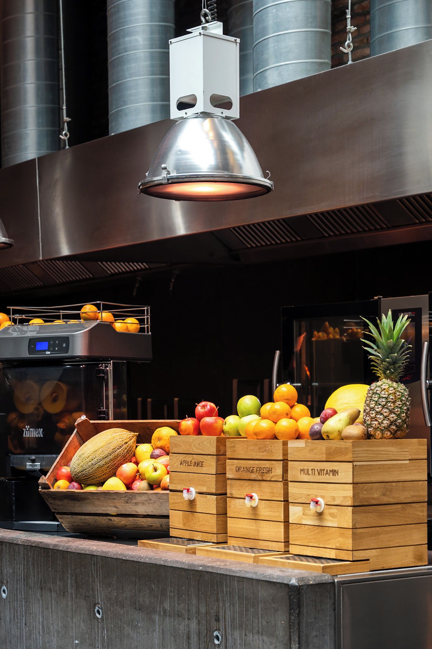 A fruit display with wooden crates labeled 'APPLE JUICE,' 'ORANGE FRESH,' and 'MULTI VITAMIN.'