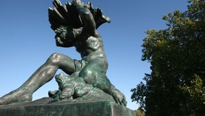 A bronze statue of a reclining figure with a child.