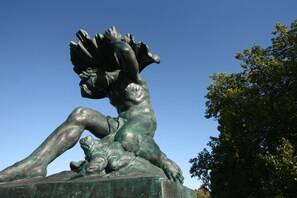 Een bronzen beeld van een uitgestrekte figuur met een kind.