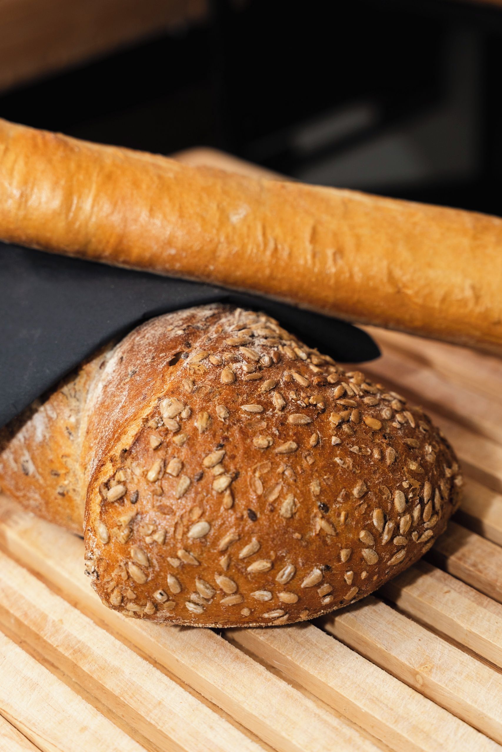 A loaf of bread with seeds on a wooden surface.