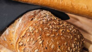 A loaf of bread with seeds on a wooden surface.