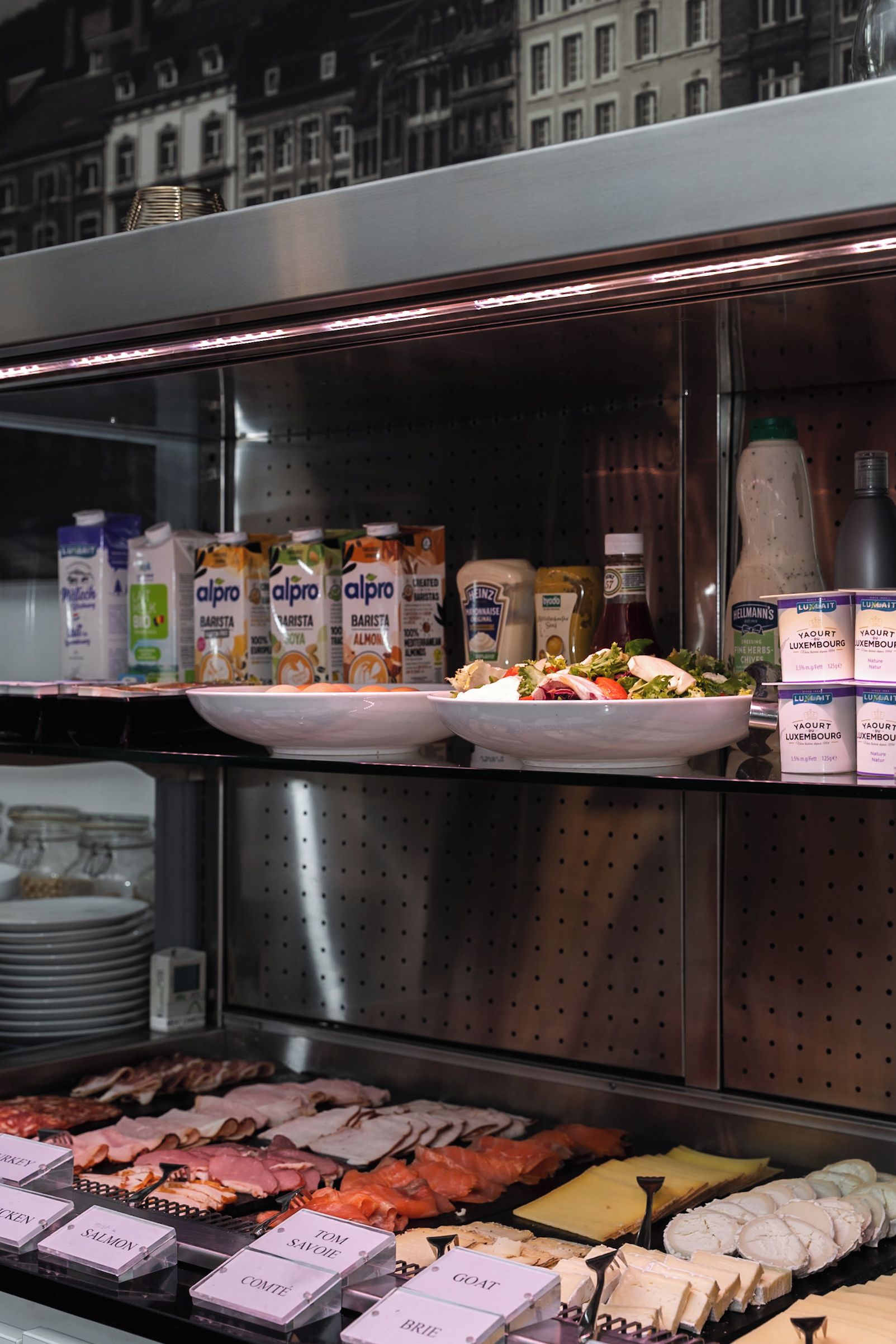 Un bufé con diversas opciones de comida, incluyendo carnes, quesos y productos lácteos.