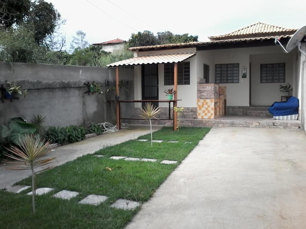 A residential property with a paved patio, a small garden with potted plants, and a blue outdoor furniture set.