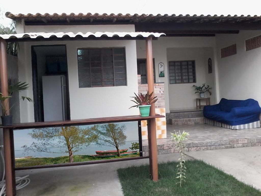 Une maison avec un balcon, un petit jardin et un canapé bleu.