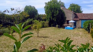 A house with a stone facade, a small garden, and a blue pool. - Rural Farmhouse with Spacious Garden near Charroux (Charroux)