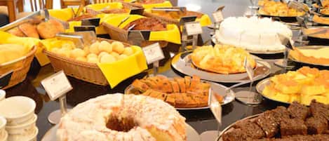 A buffet with various dishes, including a large cake and several baskets of food.