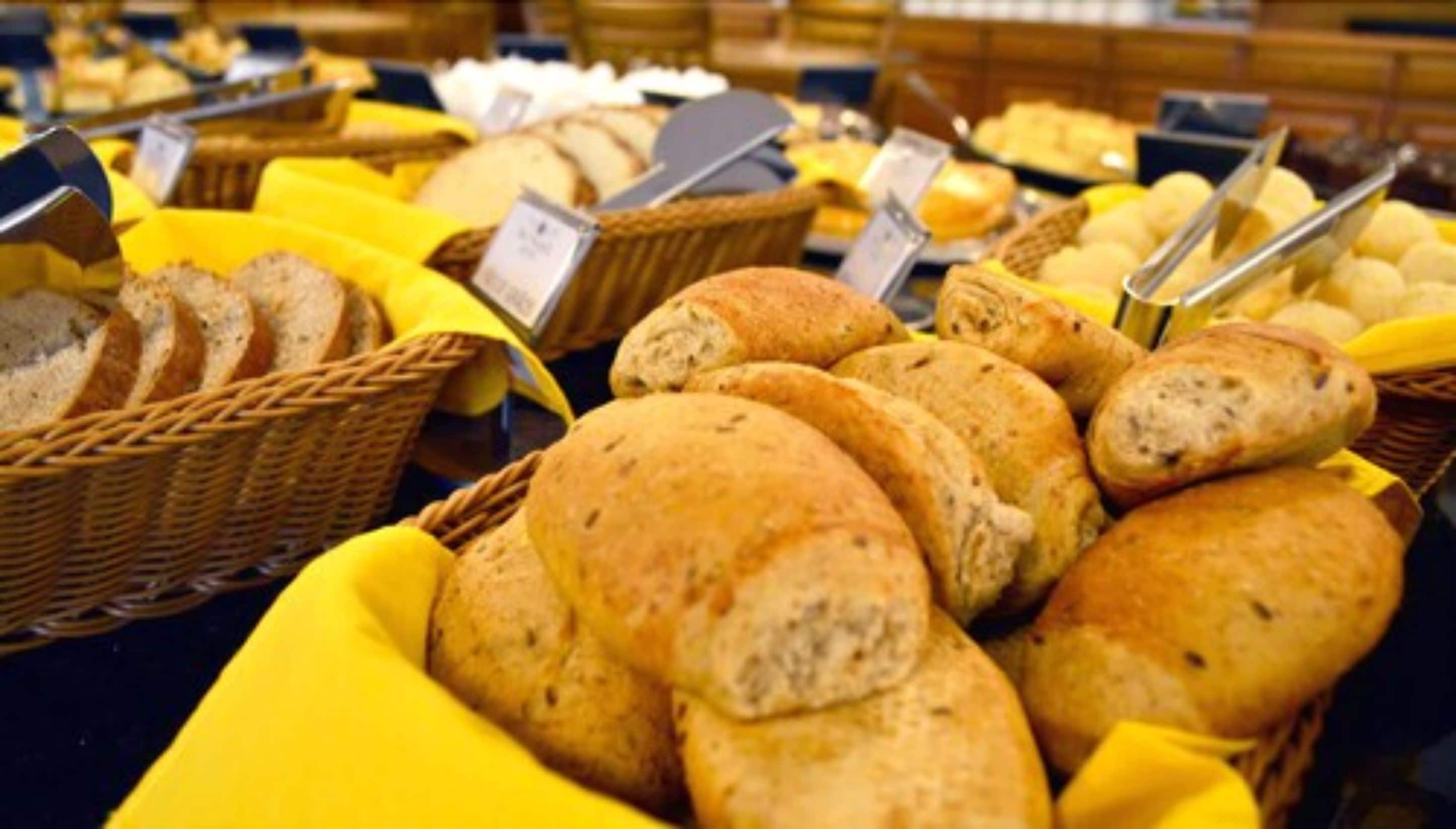 A variety of breads and pastries displayed in baskets and trays.