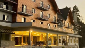 A multi-story hotel with balconies and a well-lit entrance. - Sky Palace Hotel (Gramado)