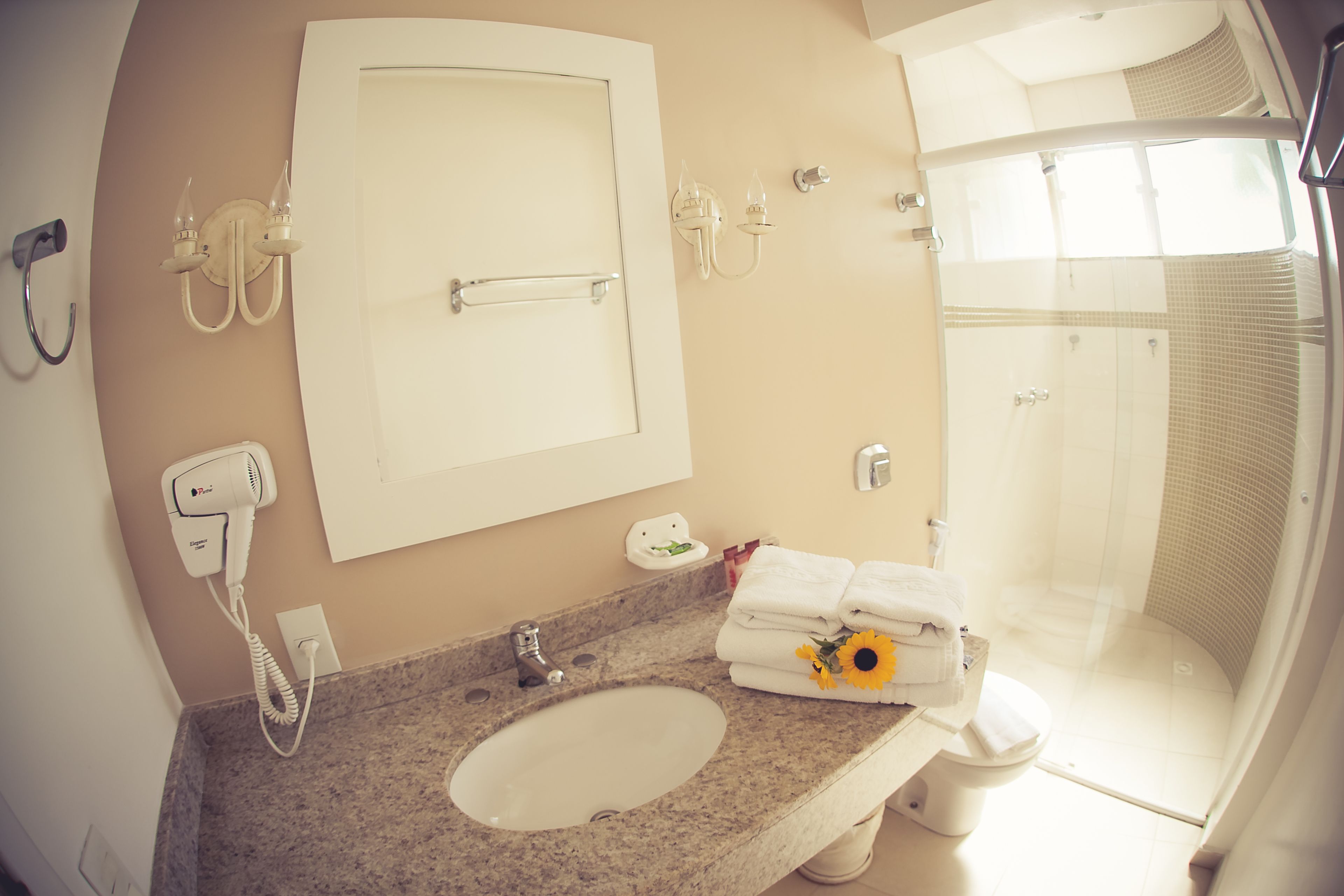 Ein Badezimmer mit Waschbecken, Spiegel, Handtuchhalter und Dusche.