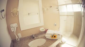 Ein Badezimmer mit Waschbecken, Spiegel, Handtuchhalter und Dusche.