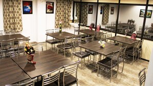 Un espace repas comprenant plusieurs tables et chaises, disposées de manière à créer un aménagement spacieux.