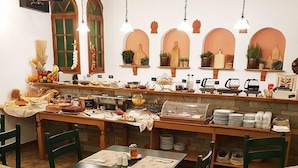 A restaurant with a buffet setup, including a variety of food items and a coffee station. - Hotel Apollo (Delphi)