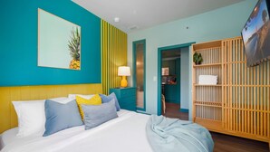A bedroom with a bed, a TV, a wooden wardrobe, and a bathroom visible through an open door. - ‼️Stylish Oceanfront‼️ Stay on Iconic Ocean Drive (Miami Beach)