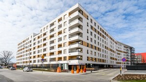 Un hotel moderno de varios pisos, con fachada blanca, balcones y ubicación en esquina.