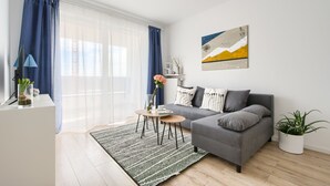 Una sala de estar moderna con un sofá gris, una mesita de centro y una planta en maceta.