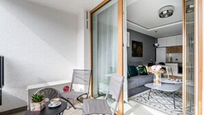 A modern apartment with a balcony, a dining area, and a living room. - M&R Apartament Airport&Business DeLuxe Cybernetyki (Warsaw)