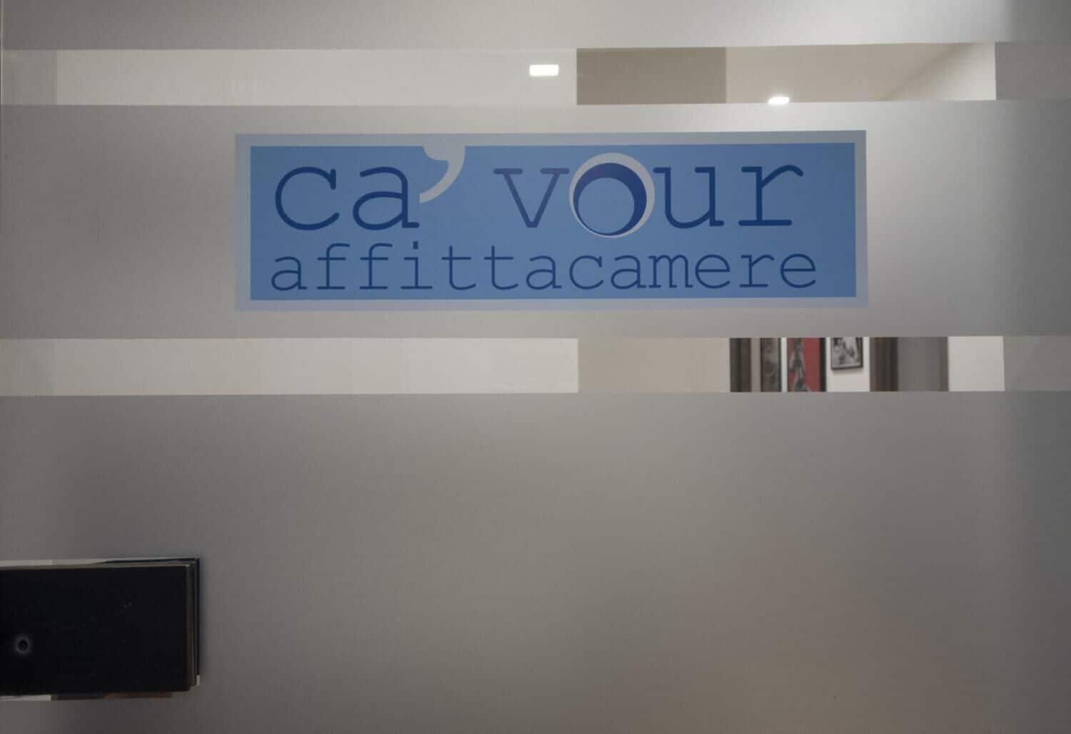 A sign with the text "ca'VOUR affittacamere" on a wall.