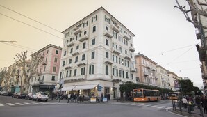 Un edificio de varios pisos con un estilo arquitectónico clásico, que cuenta con balcones y un local comercial en la planta baja.