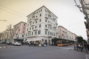 A multi-story building with a classic architectural style, featuring balconies and a ground-floor commercial space.