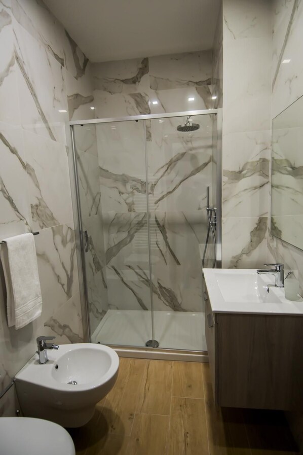 Ein Badezimmer mit Duschkabine, Waschbecken und Bidet.