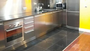 A modern kitchen with stainless steel appliances, a microwave, and a refrigerator.