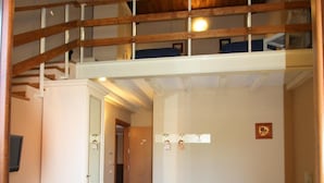 A room with a bunk bed, a desk with a chair, and a bed with a blue cover. - La Chioccia (Valmontone)