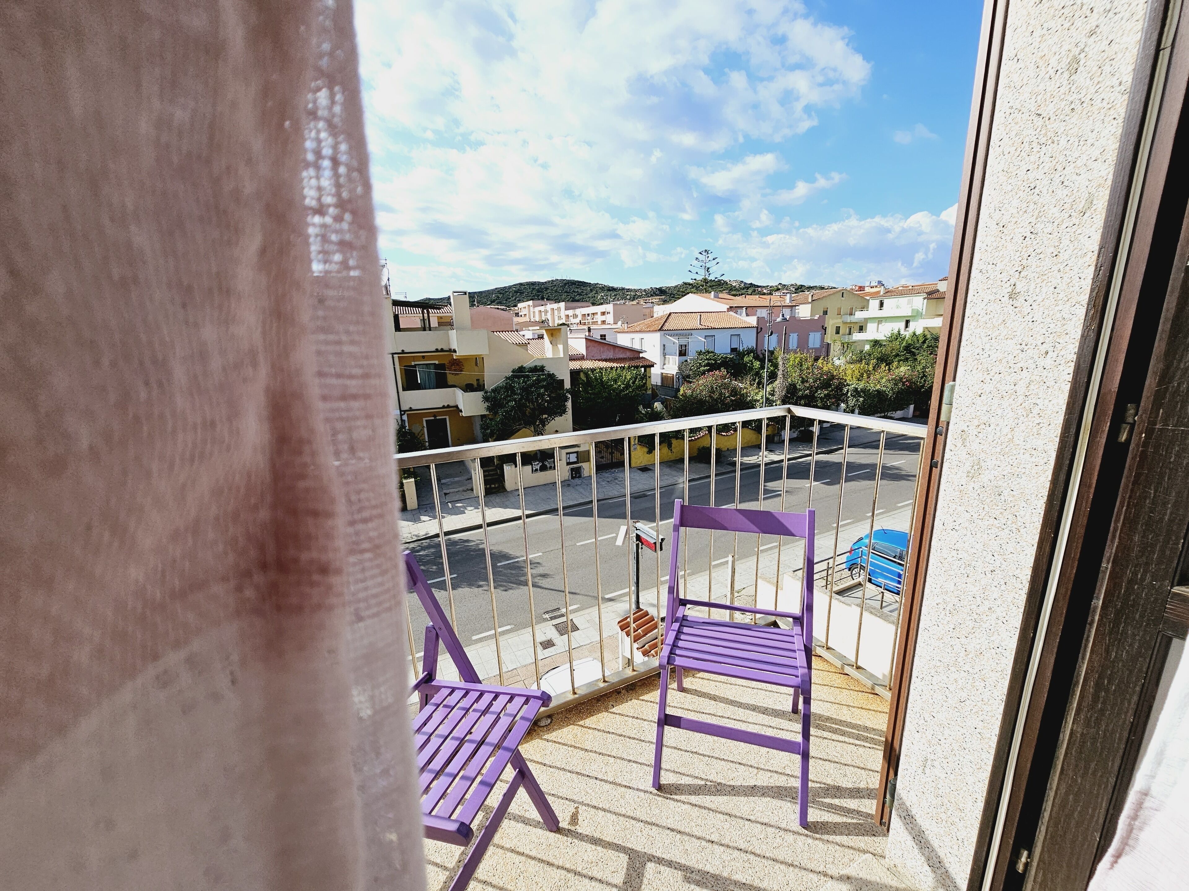 A balcony with a clear view of the street and buildings below.