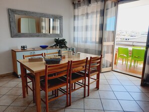 Enjoy meals in this dining area with a table, chairs, and a large mirror, plus access to a balcony with outdoor seating.
