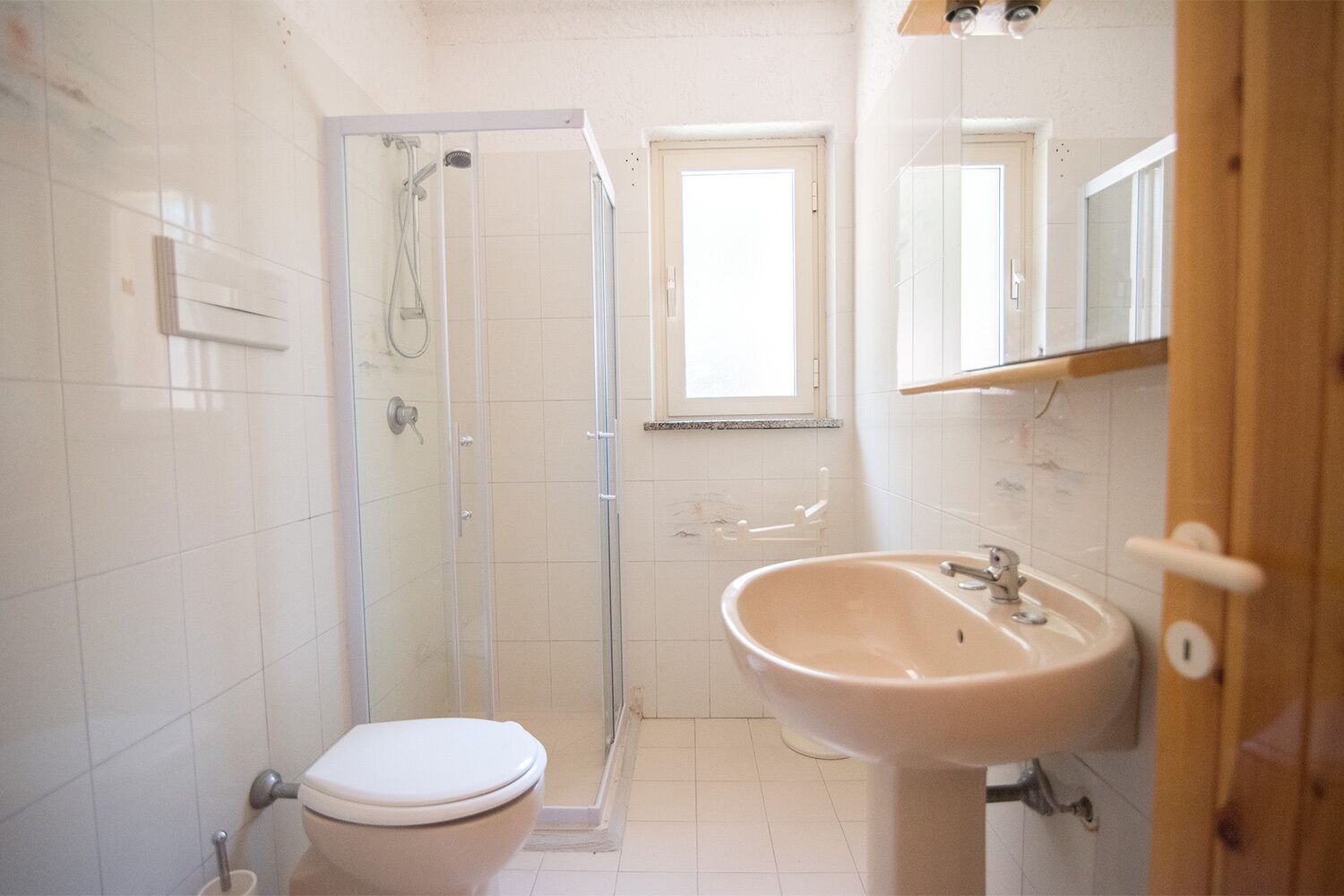 Een badkamer met toilet, douche en wastafel.