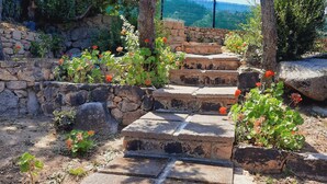 A stone staircase leading up to a stone wall, surrounded by greenery and flowers. - Villette Panoramiche Filetta (Santa Teresa di Gallura)